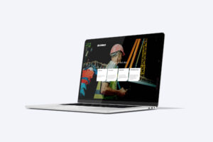Webseite von Stocker Bau „Erfolgreich. Seit 1863“ mit Bauarbeiter vor einem Kran auf einem Laptop